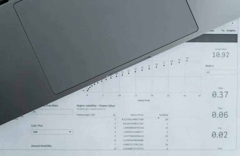 Top-down view of analytical data sheets and a laptop on a desk